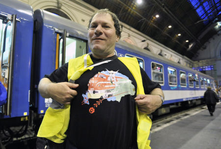 emsei Zoltán vonatkísérő mutatja a Csíksomlyó expressz emblémájával díszített pólóját a zarándokvonat indulása előtt a Keleti pályaudvaron