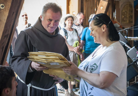 Böjte Csaba ferences rendi szerzetes, a Dévai Szent Ferenc Alapítvány vezetője (b) átveszi a Csíksomlyó Expresszen összegyűlt adományt Frigyesy Ágnes szervezőtől a csíksomlyói Szent István Gyermekvédelmi Központban