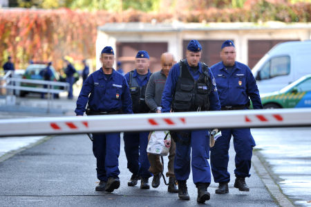 Rendőrök vezetik át 2012. november 4-én a kaposvári börtönbe a megyei bíróság épületéből az egyik gyanúsítottat