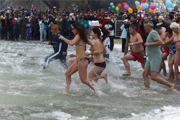 Résztvevők a 3 Celsius-fokos Balatonban a 4. Újévi csobbanás elnevezésű rendezvényen a szigligeti strandon